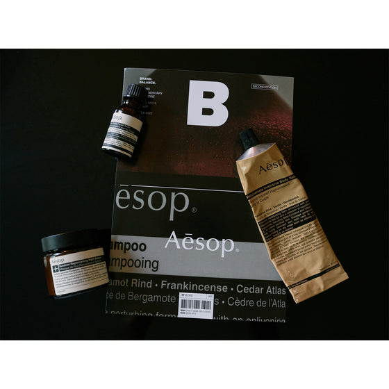 Magazine B - Issue 16 Aesop. A page showcasing the book surrounded by a selection of Aesop products, emphasizing the brand's elegant packaging and minimalist design.