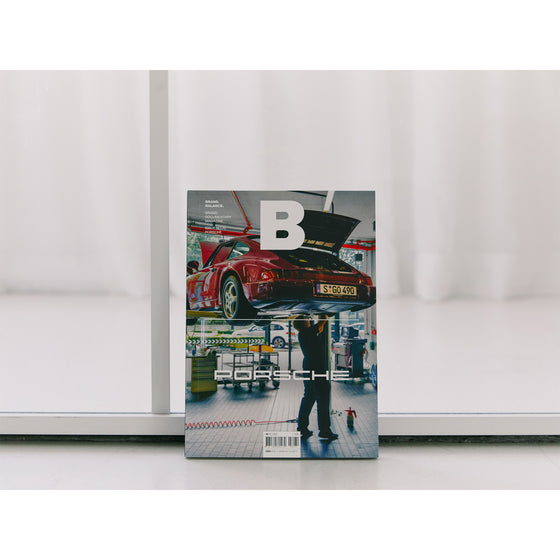 Magazine B - Issue 70 Porsche. The magazine is positioned against a clean white background, emphasizing the sleek design and luxury of Porsche while focusing on the brand’s high standards and innovation.