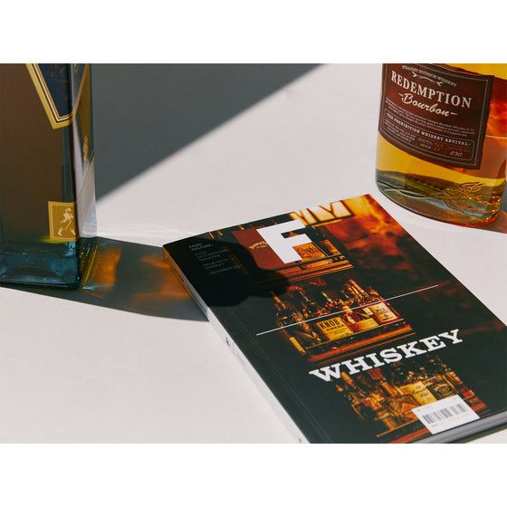 Magazine F - Issue 19 Whiskey
The magazine rests next to a bottle of whiskey and a glass, highlighting the connection between the publication and the rich world of whiskey.