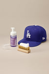 Jason Markk Hat Care Kit. Kit in use, showing the Premium Cleaning Brush gently cleaning a hat with the Ready-To-Use Hat Cleaner for effective maintenance.